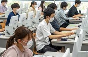 パソコンの前に座りプログラミングする学生たちの様子